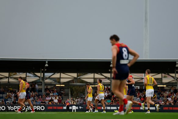 Players leave the field for a lightning delay during the 2026 AFL AAMI Community Series match between the Melbourne Demons and the Richmond Tigers at Mars Stadium.