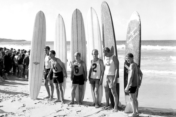 Surfers line up with longboards at Manly in 1964.