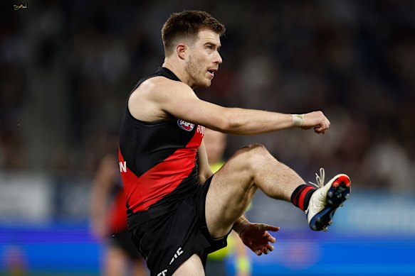 Zach Merrett of the Bombers kicks the ball.