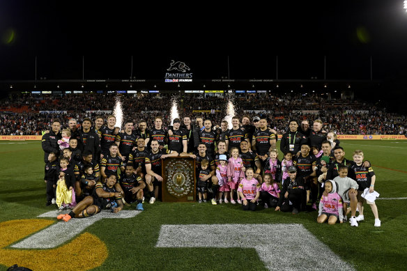 Panthers players and their families with the JJ Giltinan Shield after beating the Cowboys on Saturday night.