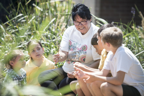 Aunty Maxine teaches kids about bush food in the Chifley Public School garden.