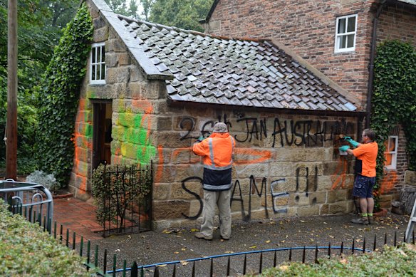 Workers clean graffiti off Cooks’ Cottage in the Fitzroy Gardens in 2014.