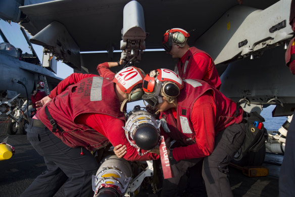 Sailors prepare to load ordnance on an F/A-18E Super Hornet assigned to the Sidewinders of Strike Fighter Squadron 86 on the flight deck of the aircraft carrier USS Dwight D. Eisenhower.