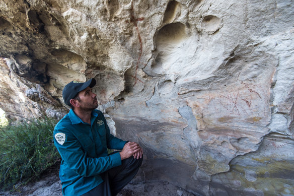 A ranger with Indigenous rock art in the Grampians.