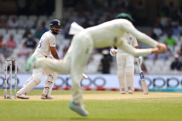 Steve Smith dives to catch Virat Kohli.