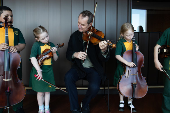 ACO artistic director Richard Tognetti with pupils from St Marys North Public School: (from left) Tanginoa Halaifonua-Palu, 6, Ava Tuckwood, 6, and Rebel Nordsven, 6, tune up before they play on Friday.
