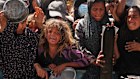 Palestinians struggle to get donated food at a community kitchen in Khan Younis.