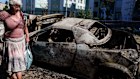 A local woman walks past cars destroyed by a Russian strike in Kyiv, Ukraine last week.