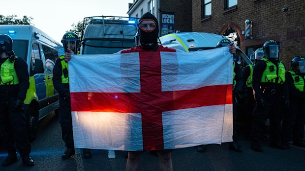 A man holds an English flag during the Epping protest.
