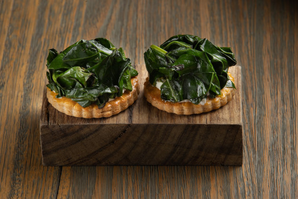 The opening snack of charred broccoli leaves, curd and buttery house-made pastry.