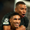 Achraf Hakimi (centre) celebrates with PSG’s other goalscorer, Kylian Mbappe (right) and Vitinha.