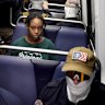 A commuter sits as masked members of the white supremacist Patriot Front ride the Washington subway on July 4.