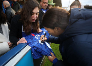 Sam Kerr signs a fan's shirt after Chelsea's win.