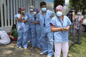 Medical workers in Lima who say they work directly with COVID-19 patients protest they are not in line to get shots of China’s Sinopharm vaccine.