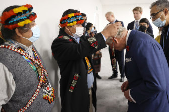 Prince Charles is given a necklace by Juan Carlos Jintiach, co-ordinator of international economic co-operation and autonomous indigenous development of the Amazon Basin.