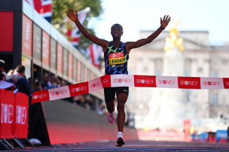 Sisay Lemma of Ethiopia crosses the London marathon finish line, before handlers took him away on fears he could infect other medallists. He was a casual contact of a confirmed COVID case.