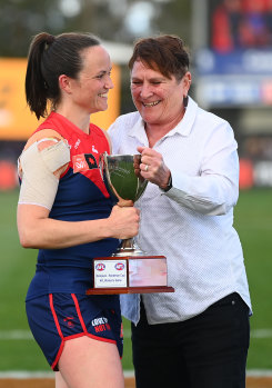 Daisy Pearce accepts the cup from Lisa Hardeman.