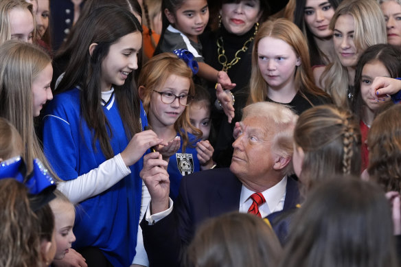US President Donald Trump hands out pens after signing an executive order barring transgender female athletes from competing in women’s or girls’ sports.
