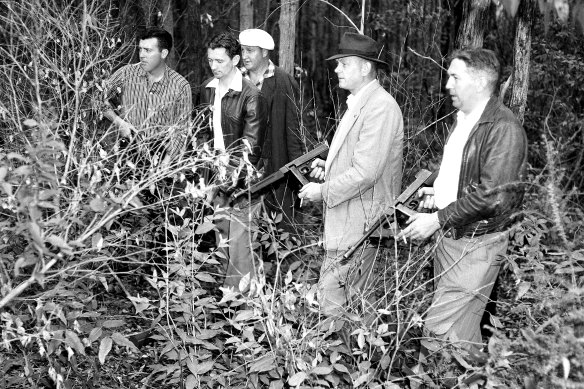 Armed police search the area on November 5, 1959.