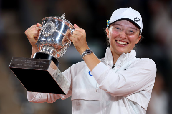 Iga Swiatek of Poland celebrates with the trophy after beating Coco Gauff.