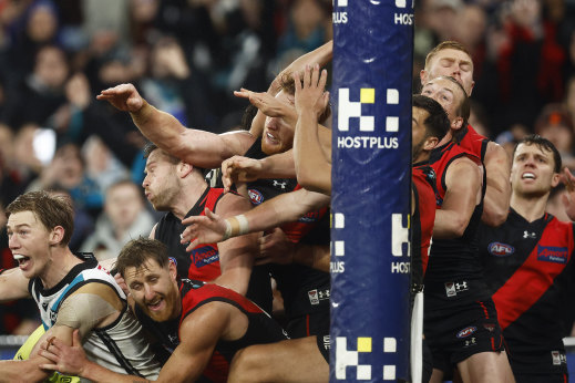 Essendon players desperately try to spoil Dan Houston’s kick