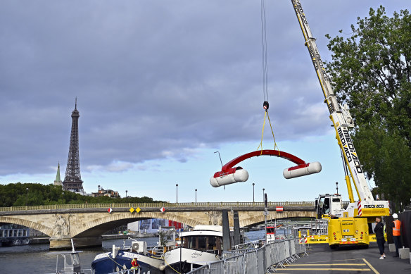 A crane dismantles the start line on the Seine in Paris after the Open Water Swimming World Cup was cancelled.