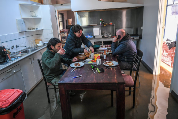 Reporter Benjamin Price (left) has breakfast with Rochester Motel owners Megan and Matt Keating on Saturday.