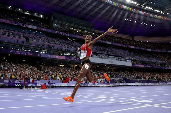 Winfred Yavi of Bahrain crosses the finish line to win the gold medal
