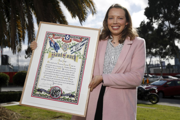 Molly Couch, Paul's daughter, with the Brownlow certificate presented to the family by the AFL earlier this month.
