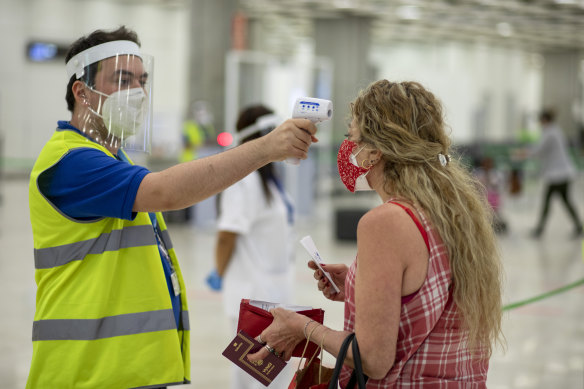 A woman has her temperature taken at Adolfo Suarez Madrid-Barajas Airport in Madrid, Spain this month. 