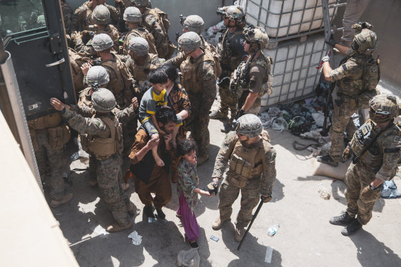 US Marines and Norwegian coalition forces assist with security at a checkpoint at the Kabul airport. A firefight on Monday left an Afghan guard dead.