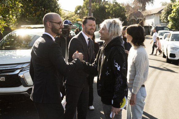 Agent Kieran Gianoudis and auctioneer Tim Snell congratulate first home buyers Wil Storch and Madi Jensen. 