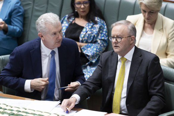 Prime Minister Anthony Albanese (right) speaking with Employment and Workplace Relations Minister Tony Burke in question time today.