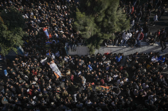 Mourners carry the bodies of eight Palestinians, some draped in the flag of the Islamic Jihad militant group.