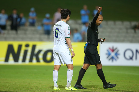 Choi Bokyung of Jeonbuk is shown a red card.