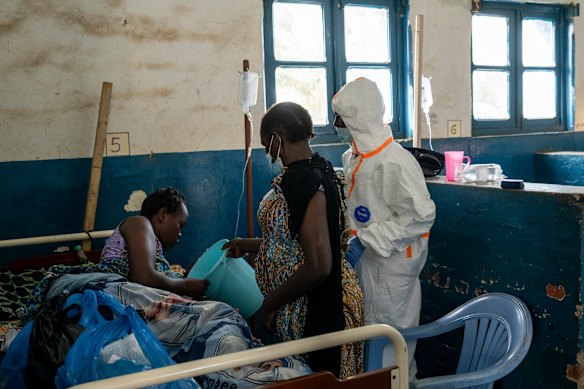 A relative and a medical worker care for Christiane Bahati shortly before she fell into a coma and died, at an Ebola ward in the mining town of Mongbwalu.