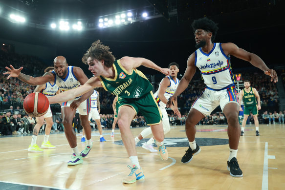 Josh Giddey stretches for the ball for  the Boomers in Monday’s game against Venezuela, ahead of opponent  Pedro Chourio.