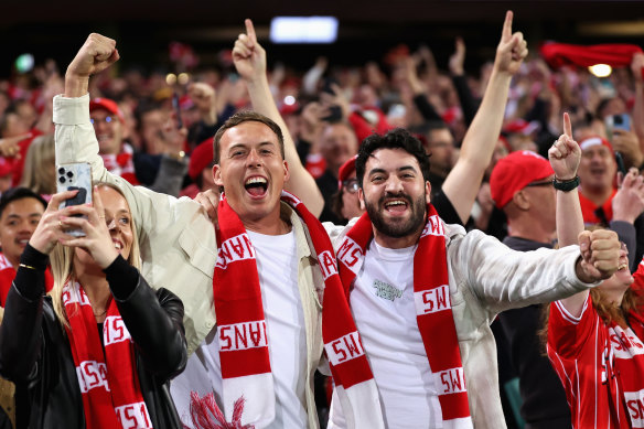 Swans fans celebrate winning the AFL preliminary final.