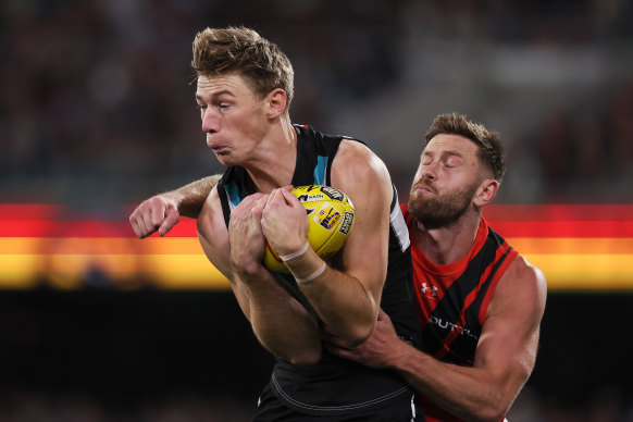 Todd Marshall of the Power marks in front of Jayden Laverde of the Bombers.