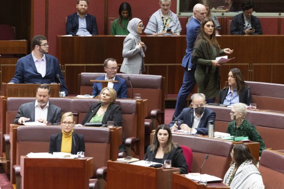The moment Fatima Payman (in grey) crossed the floor in the Senate today.