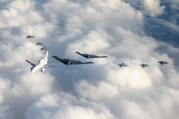 A RAAF Wedgetail (white aircraft on left) flying in formation with Australian and US jets.