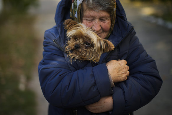 A woman warms her dog in the Ukrainian town of Kivsharivka, as temperatures fall in eastern Europe.