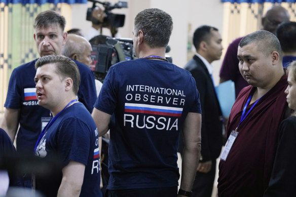 Russian election observers stand at a polling station in Phnom Penh, Cambodia.