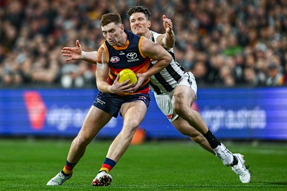 Mark Keane of the Crows competes with  Brody Mihocek of the Magpies. 