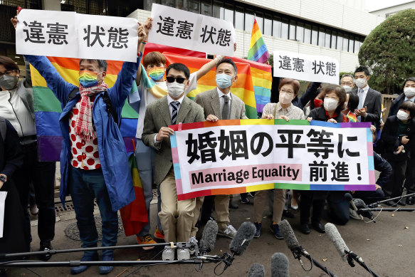 Plaintiffs hold banners reading “state of unconstitutionality” after the Tokyo District Court’s ruling on same-sex marriage in Chiyoda Ward, Tokyo, last November.