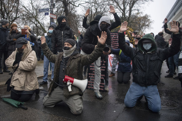 Demonstrators kneel in front of a police chain in Frankfurt, Germany, in December 2021. Several hundred participants, including members of the cross-thinkers and Reichsbürger scene, had gathered in the city centre to protest COVID regulations.