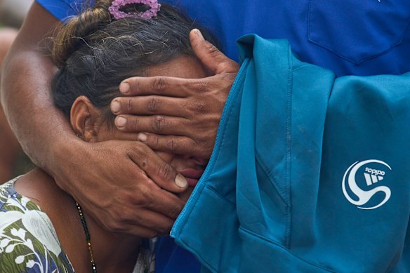 A woman consoles a relative as they wait for news of family members missing after flash flooding along the Trishuli River in Nepal.