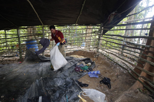 A forensic police officer inspects a camp used by human traffickers near the Thai-Malaysian border, where mass graves were found in May 2015.