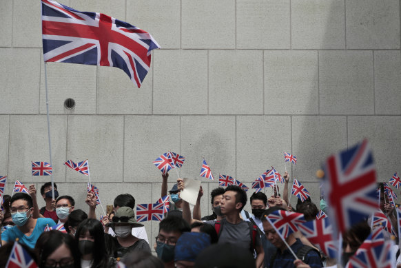 Protesters wave British flags and participate in a peaceful demonstration outside the British Consulate in Hong Kong on Sunday.