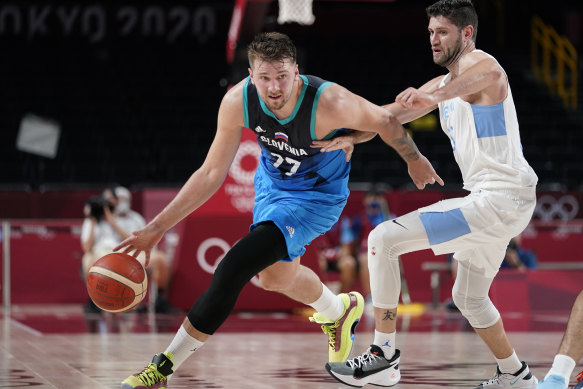 Luka Doncic drives up the court ahead of Argentina’s Patricio Garino.